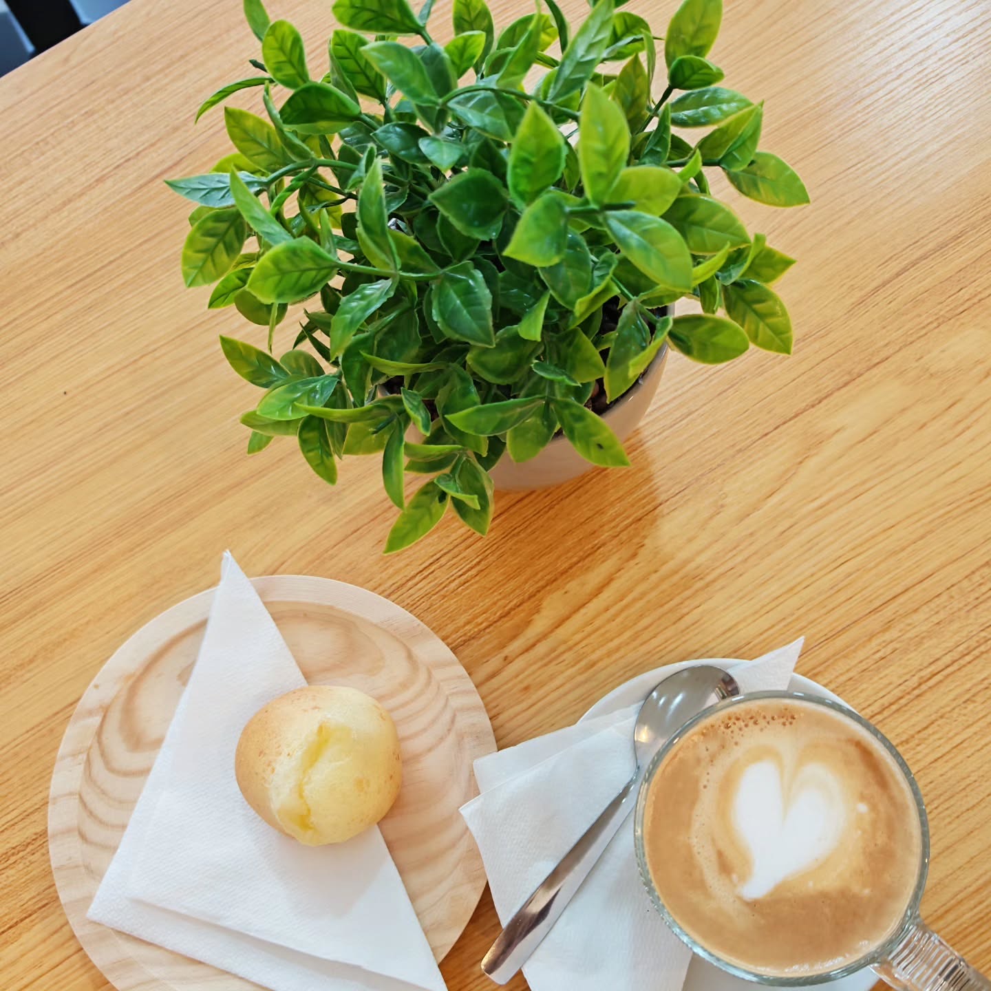 Café con leche con un corazón dibujado y un pandebono